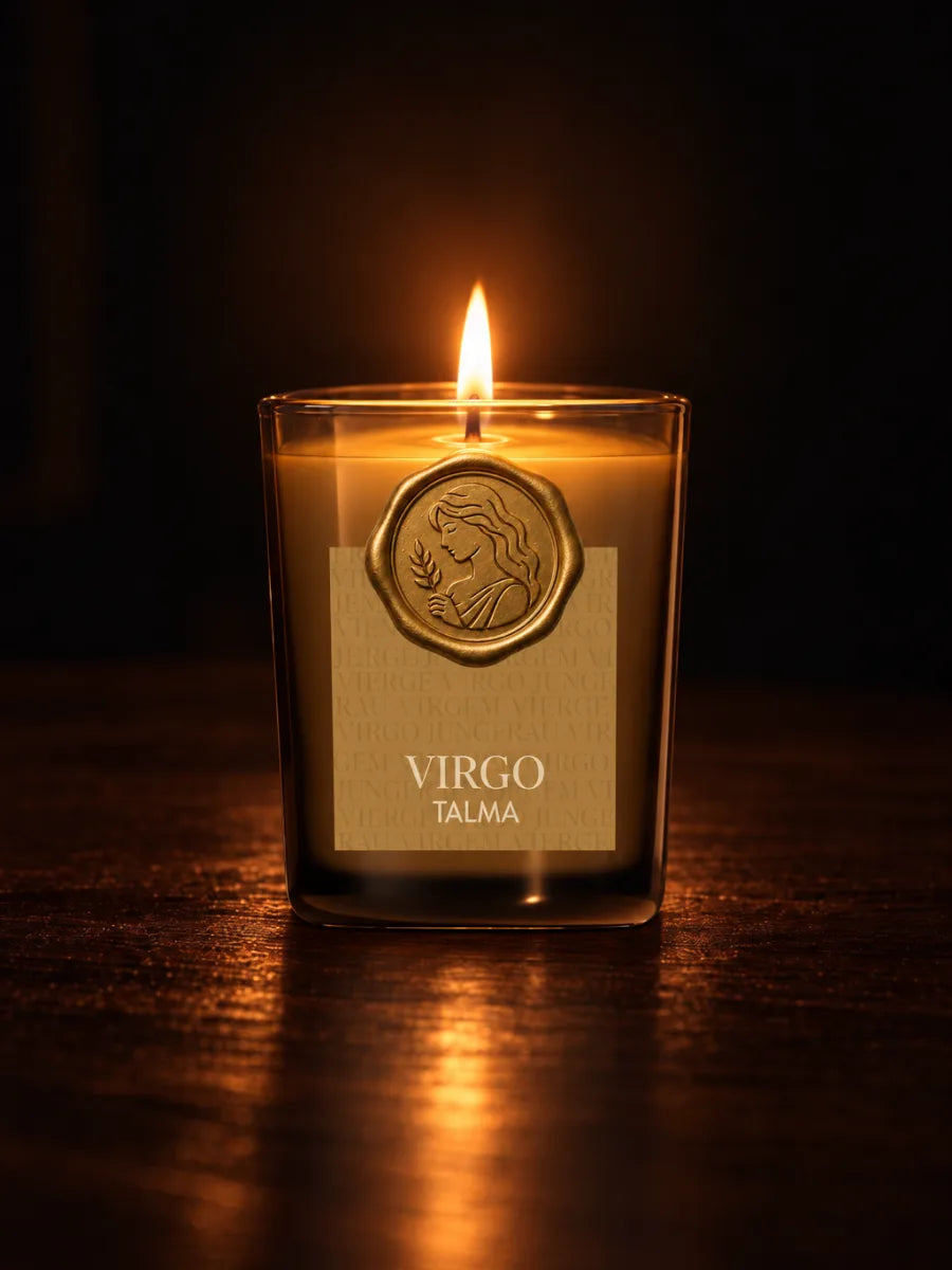 The Virgo candle lit in the dark, its wax seal on the amber glass.