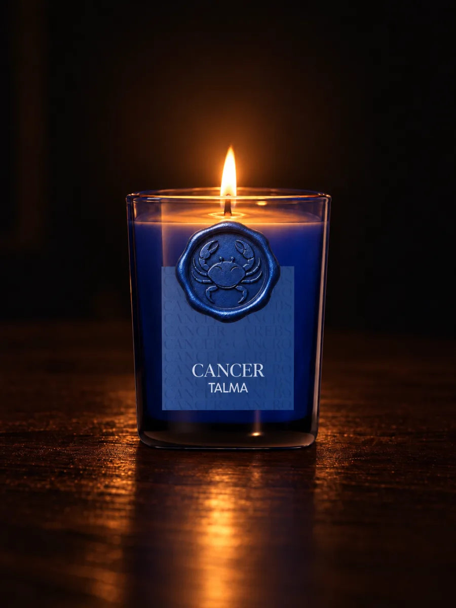 The Cancer candle lit in the dark, its wax seal on the blue glass.